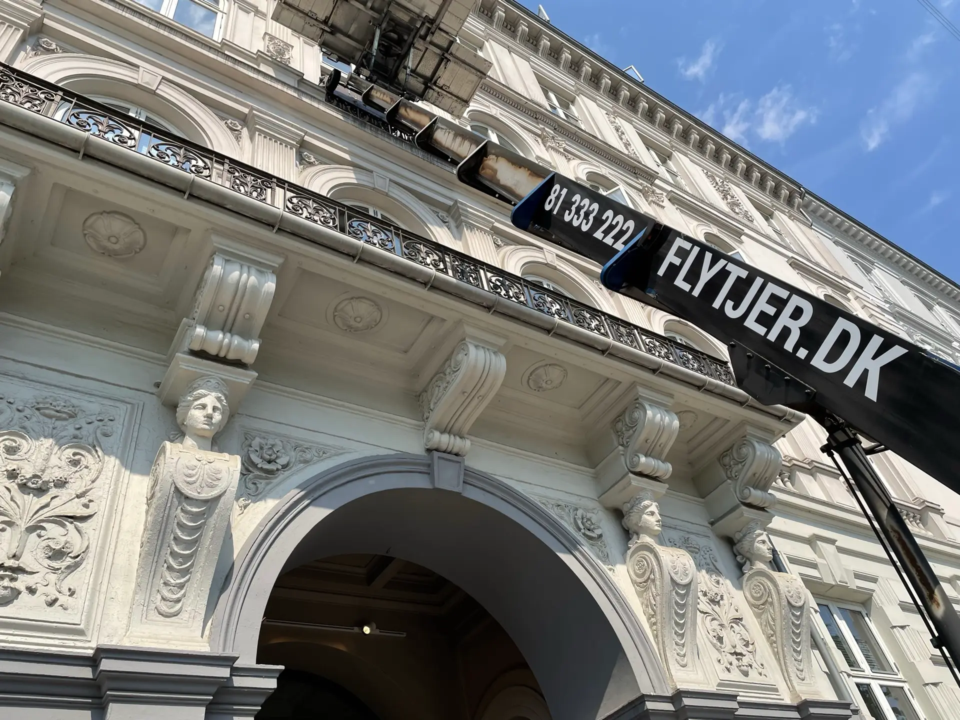 Flytteudstyr til erhvervsflytning med telefonnummer og hjemmeside på liften