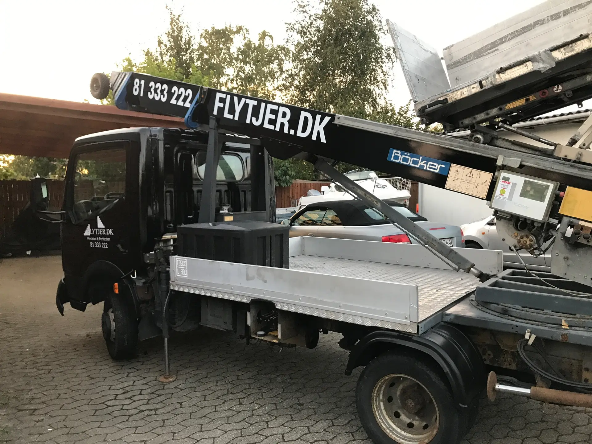 Sort flyttelift lastbil fra Flytjer, med mobil møbelhejs, klar til opgaver.