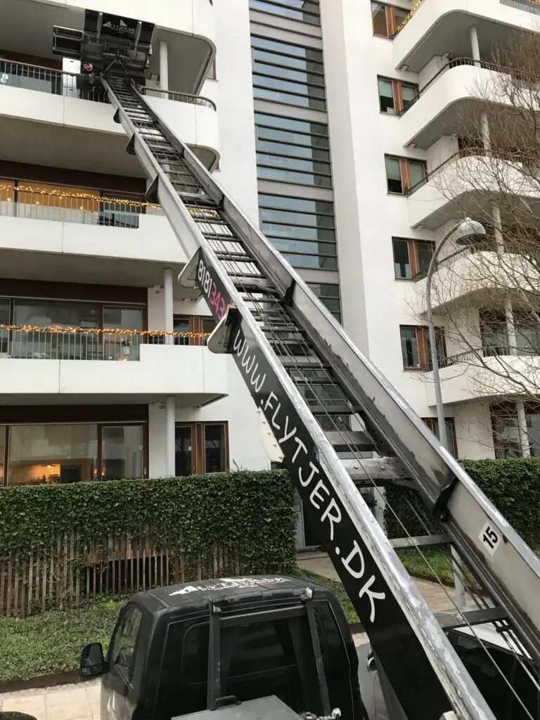 Flyttelift udfører flytning af møbler fra en altan på høj etage